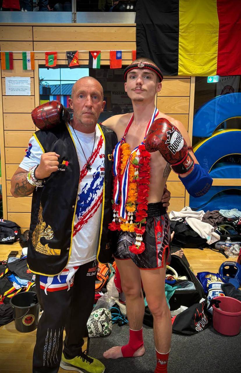Kevin avec sa médaille et sa guirlande, aux côtés du coach